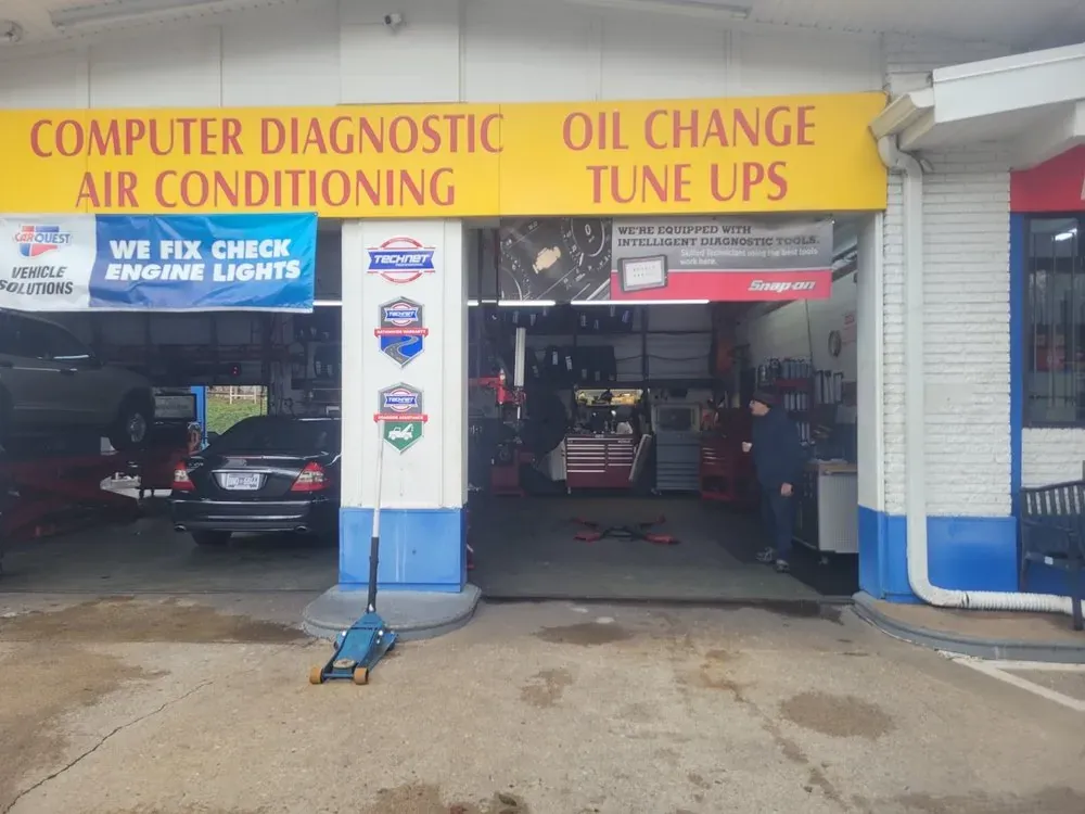 Open repair bays with computer diagnostic and oil change signs at Thompson Lane Auto